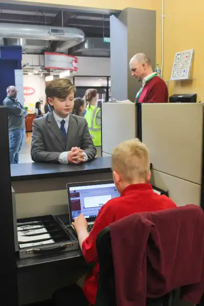 This student practices making a deposit at the Wells Fargo storefront in JA BizTown.
